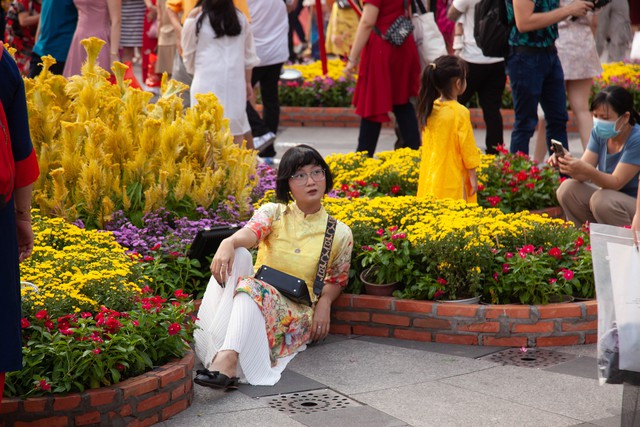 Hội chị em bạn dì diện áo dài Tết, tạo dáng đủ kiểu trên đường hoa Nguyễn Huệ - Ảnh 12.