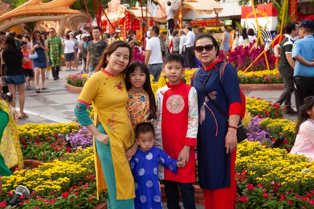 Hội chị em bạn dì diện áo dài Tết, tạo dáng đủ kiểu trên đường hoa Nguyễn Huệ - Ảnh 10.