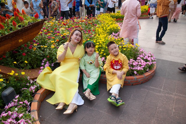 Hội chị em bạn dì diện áo dài Tết, tạo dáng đủ kiểu trên đường hoa Nguyễn Huệ - Ảnh 9.