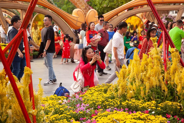 Hội chị em bạn dì diện áo dài Tết, tạo dáng đủ kiểu trên đường hoa Nguyễn Huệ - Ảnh 6.