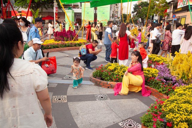 Hội chị em bạn dì diện áo dài Tết, tạo dáng đủ kiểu trên đường hoa Nguyễn Huệ - Ảnh 5.