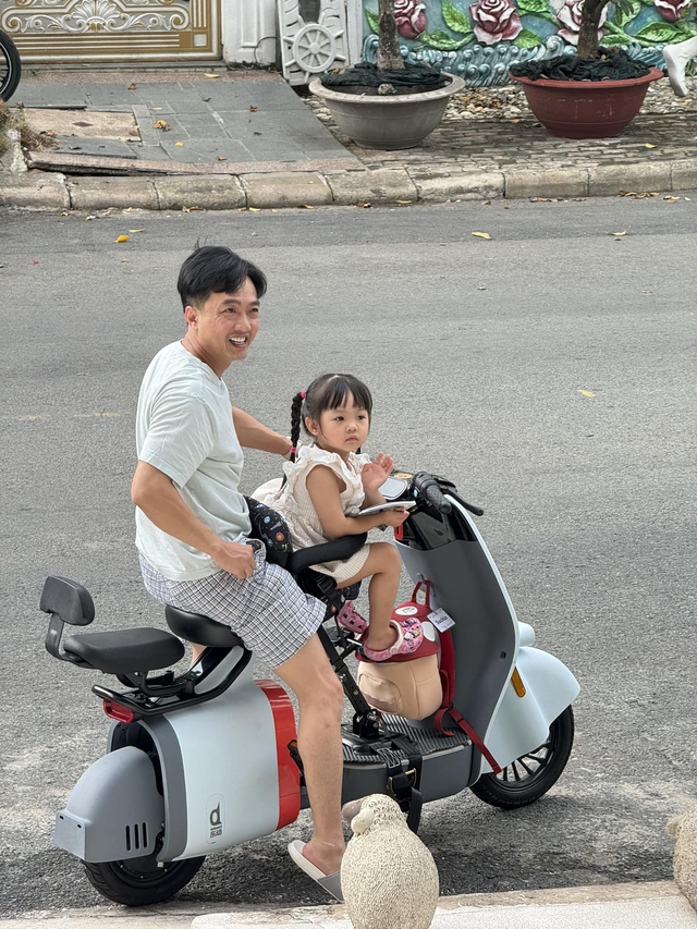 Hình ảnh giản dị của đại gia Cường Đô La: Mặc quần xà lỏn, đi dép lê, chở con đi học bằng xe hai bánh - Ảnh 2.