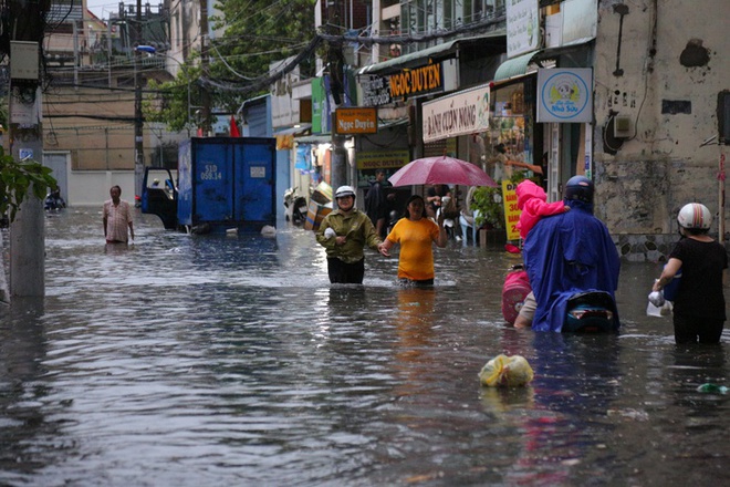 Người dân TP.HCM không kịp trở tay trong trận mưa lớn nhất kể từ đầu năm: Nước ngập gần lút bánh xe, tràn vào nhà - Ảnh 1.