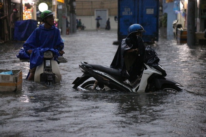 Người dân TP.HCM không kịp trở tay trong trận mưa lớn nhất kể từ đầu năm: Nước ngập gần lút bánh xe, tràn vào nhà - Ảnh 14.