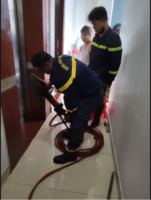 Giải cứu cô gái cùng cháu bé 2 tuổi mắc kẹt trong thang máy - Ảnh 2.