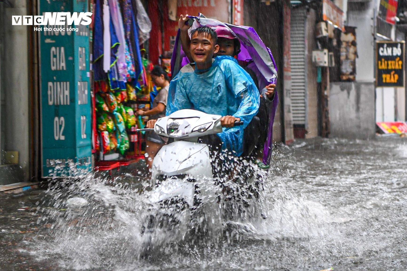 Hà Nội mưa từ sáng đến chiều, xe cộ bì bõm 'bơi' trên đường- Ảnh 7.