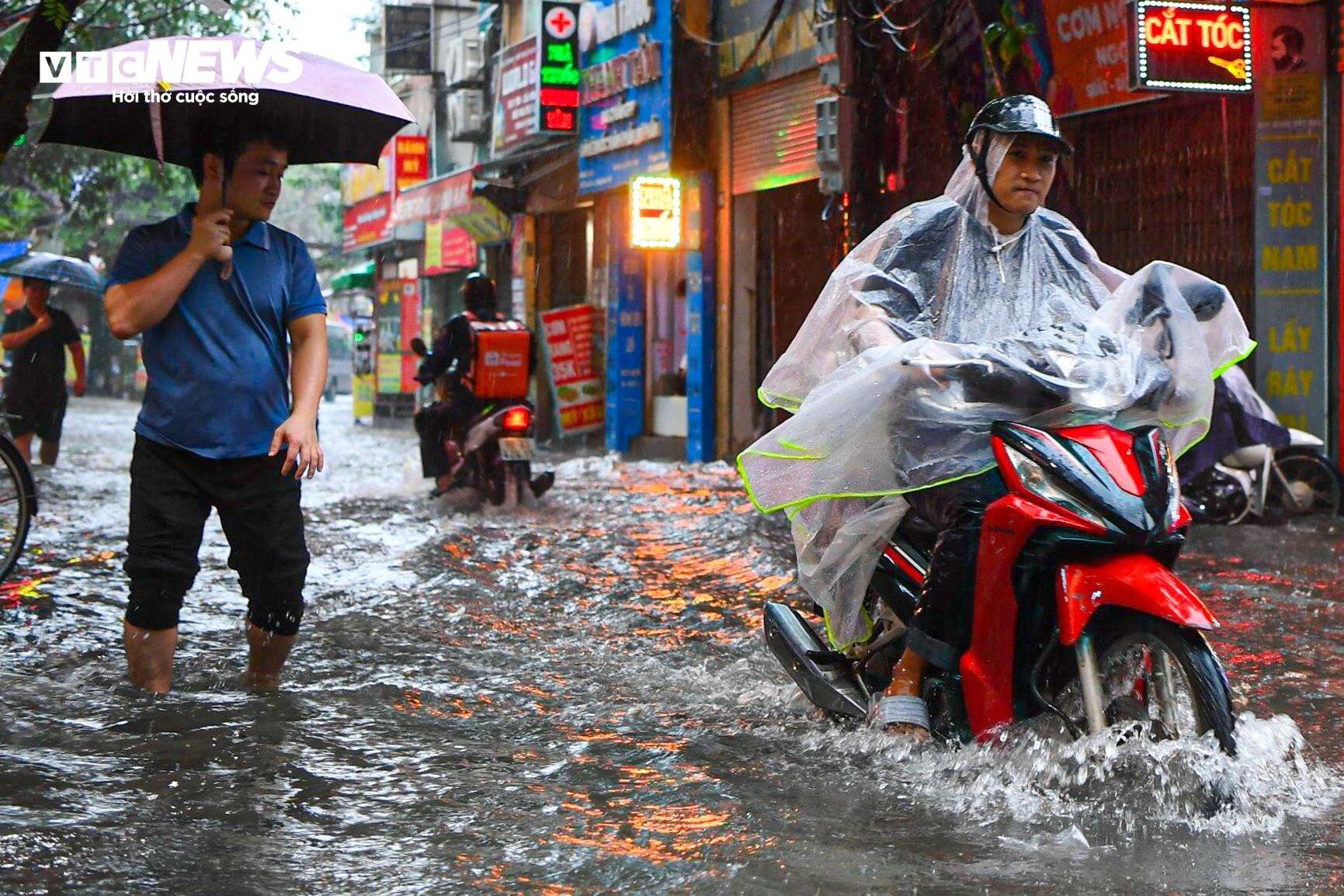 Hà Nội mưa từ sáng đến chiều, xe cộ bì bõm 'bơi' trên đường- Ảnh 4.