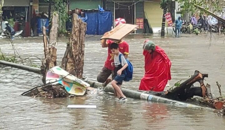 Đường vào nhà ngập hơn nửa mét, phụ huynh thuê xe kéo đón con đi học về- Ảnh 1.