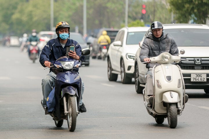 Vừa lái xe máy vừa sử dụng điện thoại bị phạt bao nhiêu tiền từ năm 2025?- Ảnh 1.