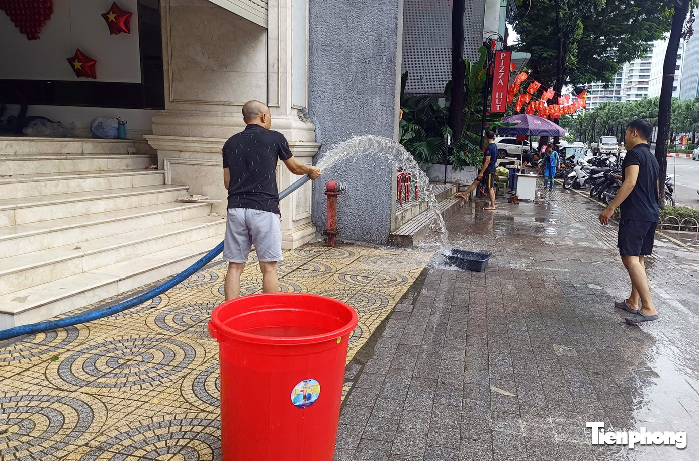 Người dân Hà Nội tất bật dọn dẹp cửa hàng, bơm nước khỏi hầm ngập- Ảnh 3.
