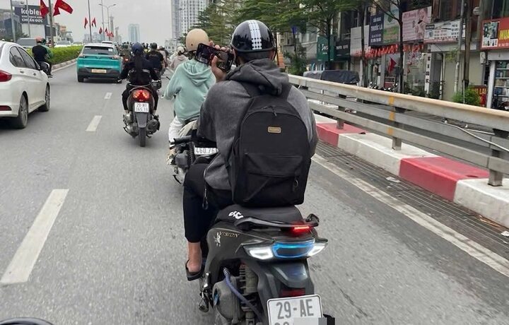 Thanh niên vừa lái xe vừa lướt điện thoại bị xử phạt 900.000 đồng- Ảnh 1.