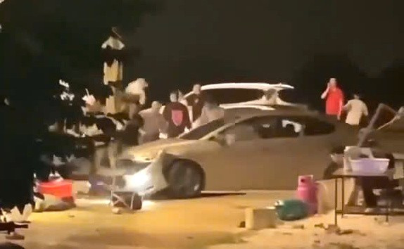 Xôn xao clip nhóm người vây đập ô tô, tài xế cho xe tiến lùi "điên loạn"- Ảnh 1.