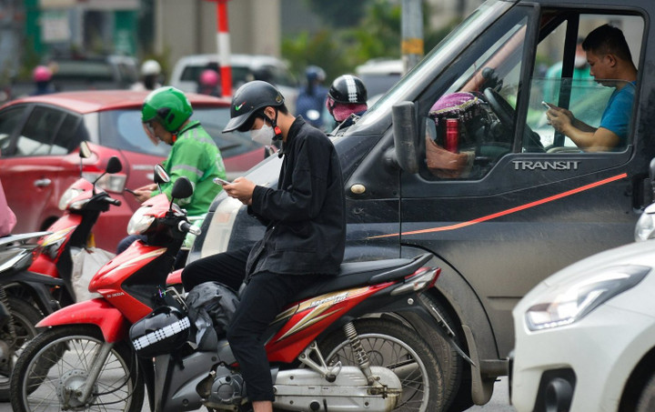 Dùng điện thoại di động khi dừng đèn đỏ có bị xử phạt?- Ảnh 1.