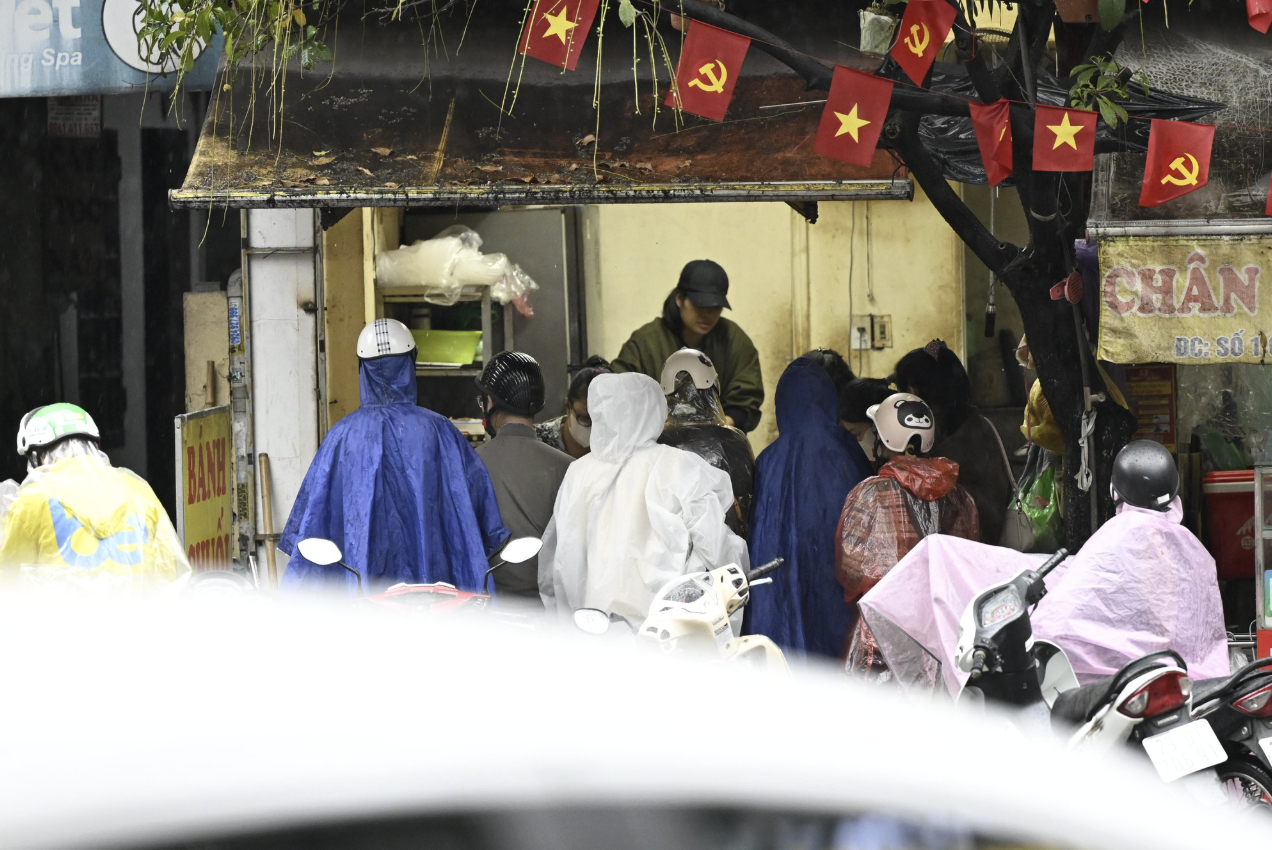 Thực tế tại h&agrave;ng b&aacute;nh chuối H&agrave; Nội khiến kh&aacute;ch "ức ph&aacute;t kh&oacute;c": Người mua vẫn tới đ&ocirc;ng nghịt d&ugrave; trời mưa lớn- Ảnh 4.