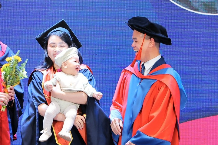 Tân thạc sĩ bế con nhận bằng, khoảnh khắc em bé mỉm cười gây "bão" mạng xã hội- Ảnh 1.