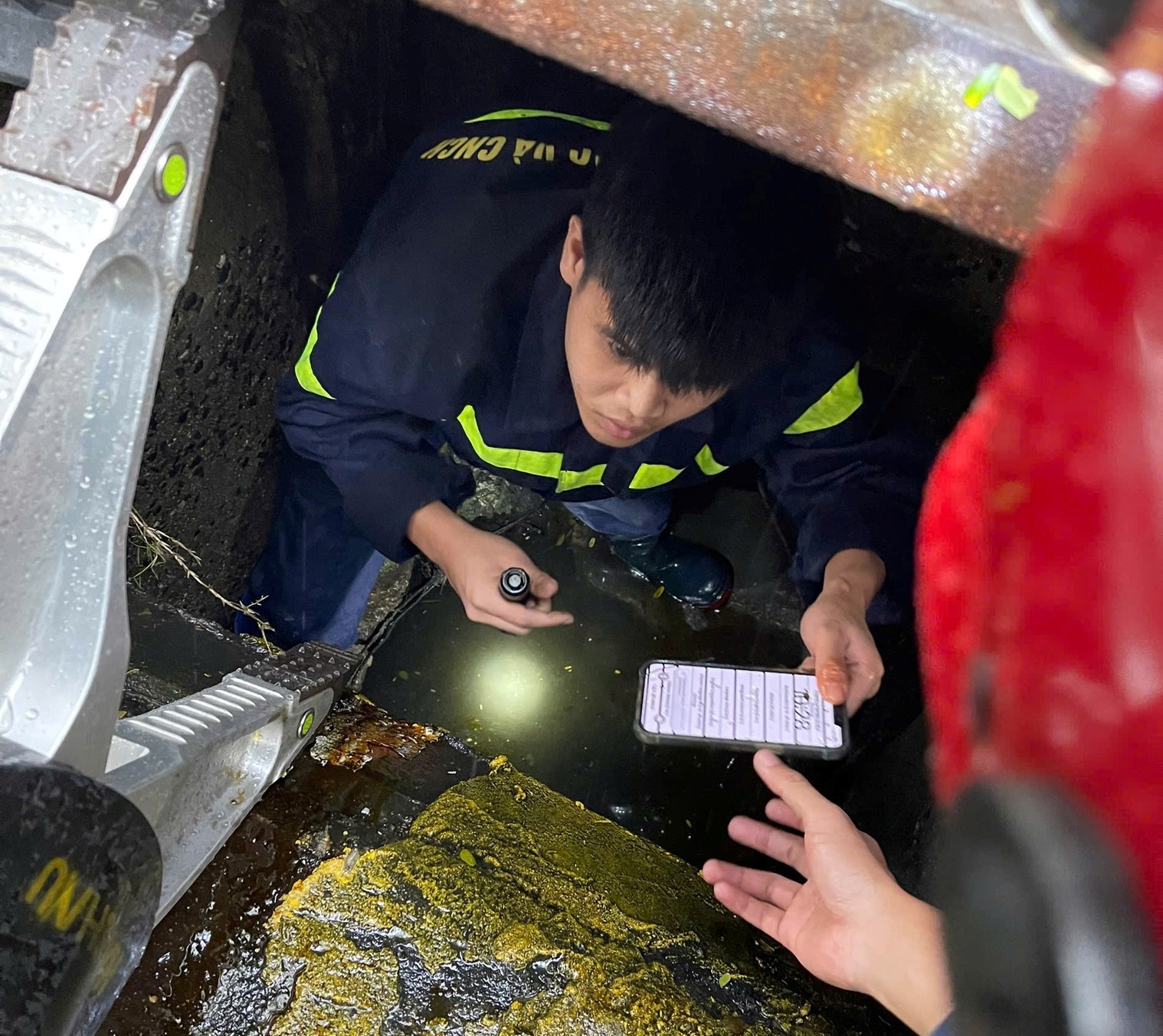 X&uacute;c động h&igrave;nh ảnh C&ocirc;ng an Đ&agrave; Nẵng chui xuống cống, t&igrave;m điện thoại cho du kh&aacute;ch- Ảnh 1.