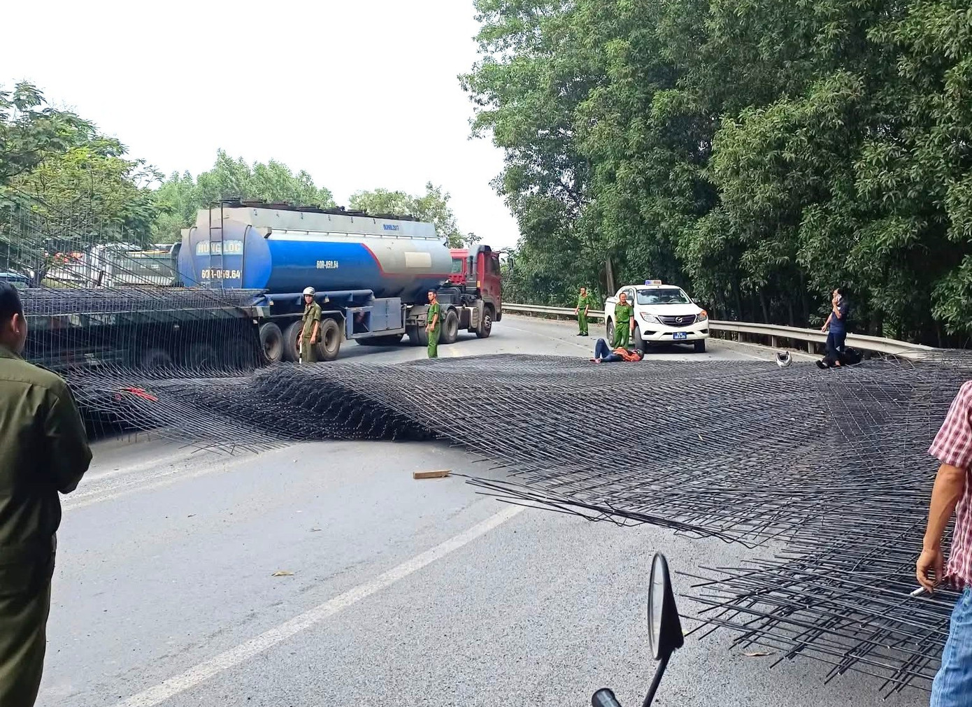 Hàng chục tấn thép rơi từ xe đầu kéo trúng 2 người đi đường- Ảnh 1.