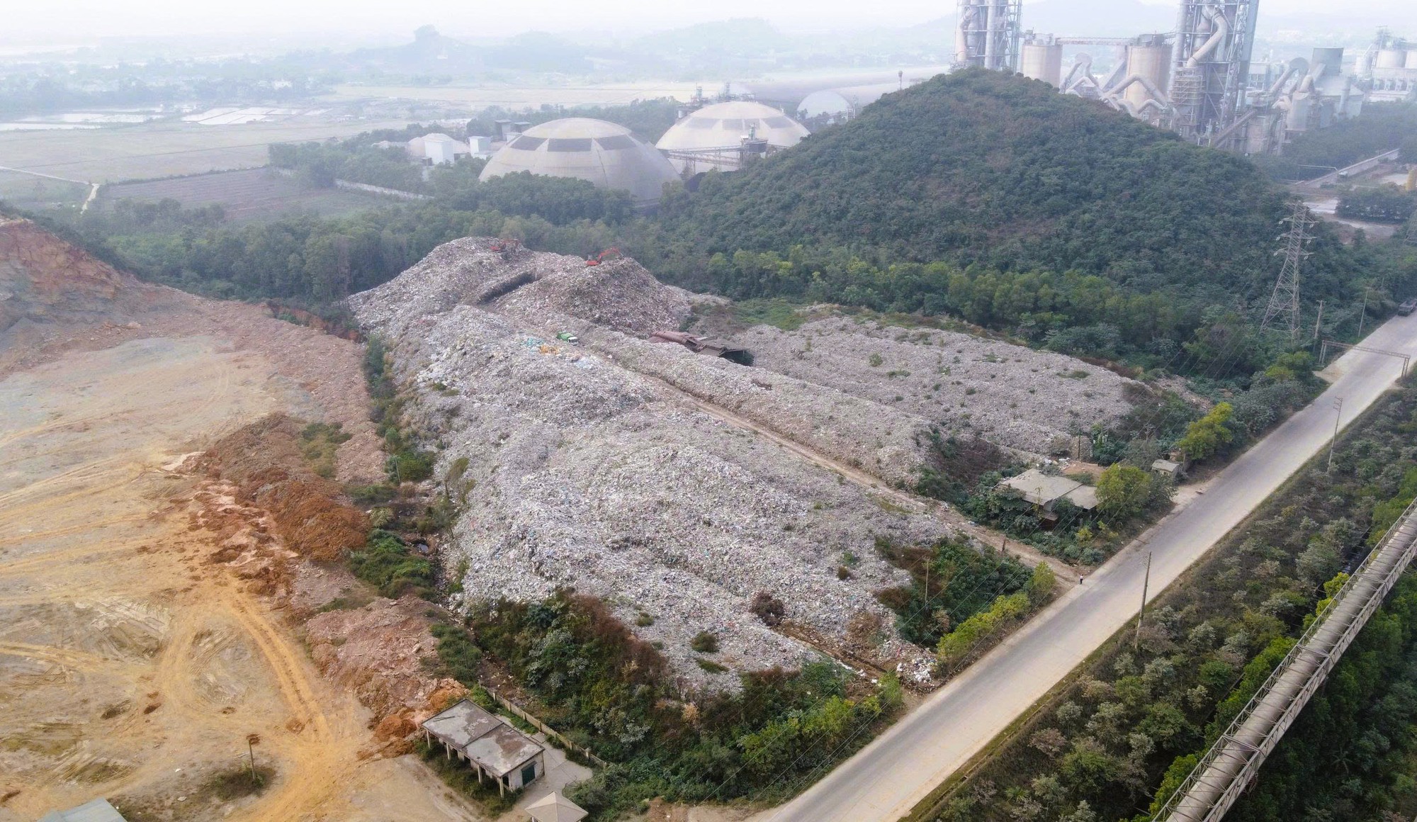 Núi rác khổng lồ gây ô nhiễm bên nhà máy xử lý rác xây 20 năm chưa xong- Ảnh 1.