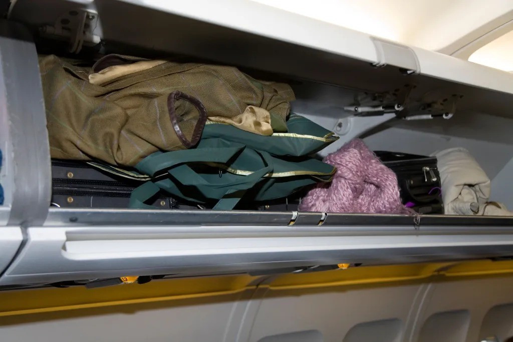 Sai lầm khi để áo khoác trong ngăn hành lý máy bay- Ảnh 1.