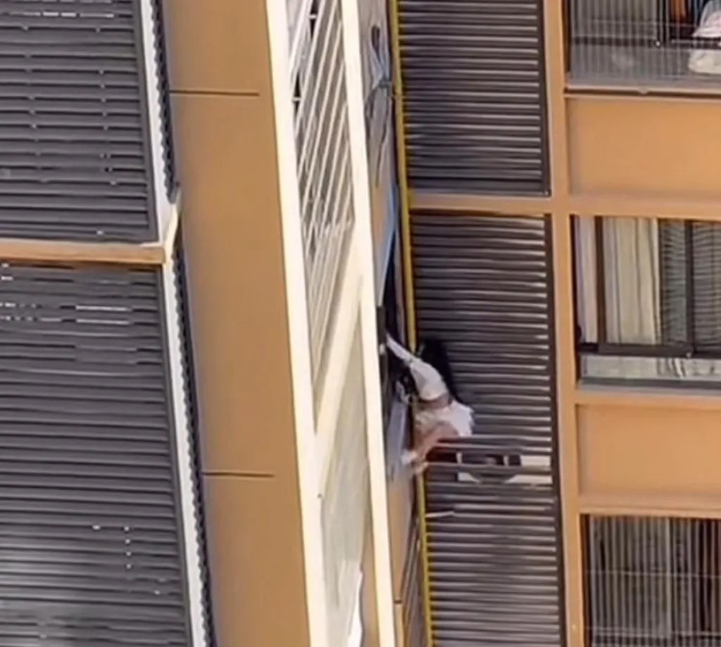 Clip cô gái trèo ra khỏi cửa sổ chung cư, bùng nổ tranh cãi khi zoom cận phát hiện người đàn ông cởi trần- Ảnh 2. Clip cô gái trèo ra khỏi cửa sổ chung cư, bùng nổ tranh cãi khi zoom cận phát hiện người đàn ông cởi trần- Ảnh 2.