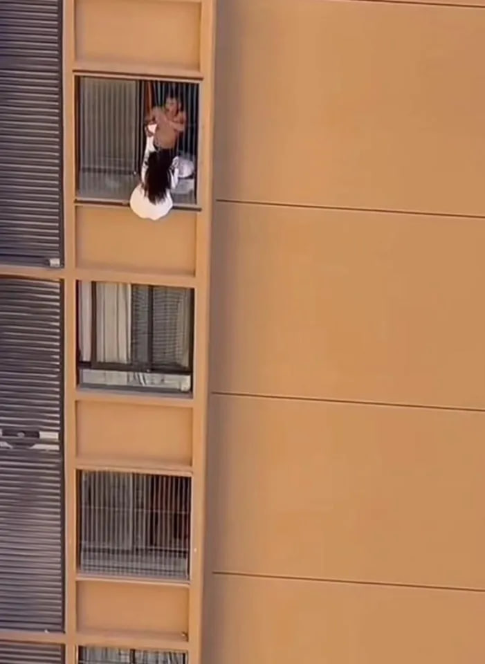 Clip cô gái trèo ra khỏi cửa sổ chung cư, bùng nổ tranh cãi khi zoom cận phát hiện người đàn ông cởi trần- Ảnh 3. Clip cô gái trèo ra khỏi cửa sổ chung cư, bùng nổ tranh cãi khi zoom cận phát hiện người đàn ông cởi trần- Ảnh 3.