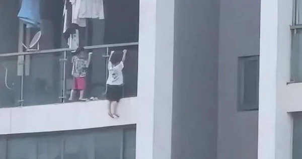 Trẻ trèo ra ngoài ban công chung cư "hít xà", hàng xóm sợ hãi la hét- Ảnh 1.