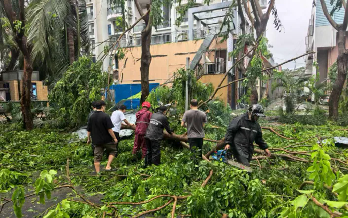 Dọn dẹp cành cây gãy, lá rụng, nước đọng, bùn đất và rác thải vương vãi sau khi cơn bão Kajiki đi qua ở Tam Á, tỉnh Hải Nam, Trung Quốc (Ảnh: China Daily)