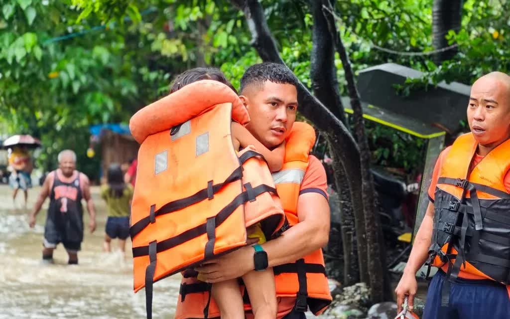 Lực lượng cứu hộ sơ tán một em nhỏ khi nước lũ dâng do bão nhiệt đới Bualoi tại thành phố Bacolod, tỉnh Negros Occidental, Philippines ngày 26/9/2025 (Ảnh: Philippine Coast Guard/AP)