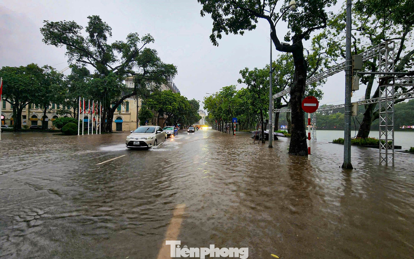 Hà Nội mưa lớn, phố cổ thành sông, khách Tây bì bõm lội giữa dòng nước- Ảnh 1.