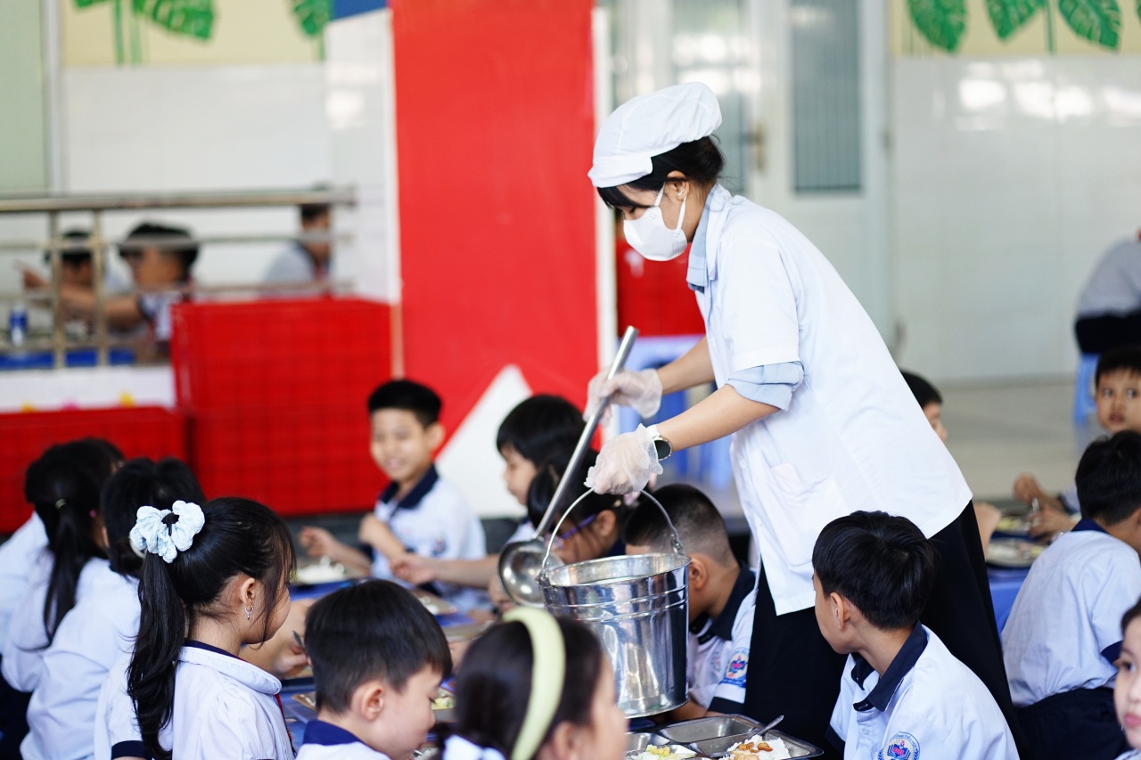 Cảnh tượng lạ tại cổng trường tiểu học ở TP.HCM mỗi buổi trưa: Phụ huynh tay x&aacute;ch cơm, người chờ đ&oacute;n con về nh&agrave;- Ảnh 2.