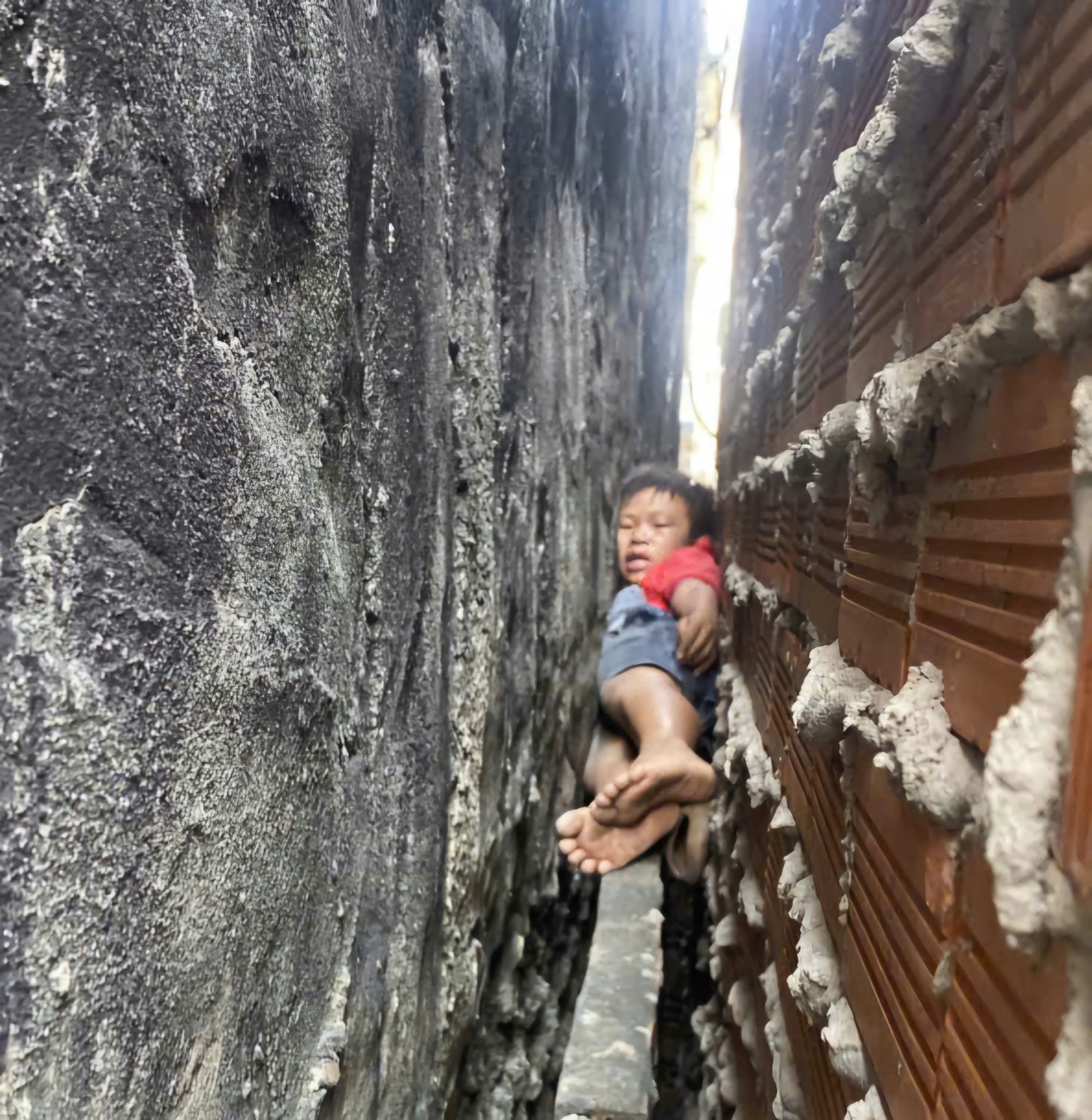 20 ph&uacute;t giải cứu ch&aacute;u b&eacute; bị mắc kẹt giữa hai bức tường nh&agrave; ở TPHCM- Ảnh 1.