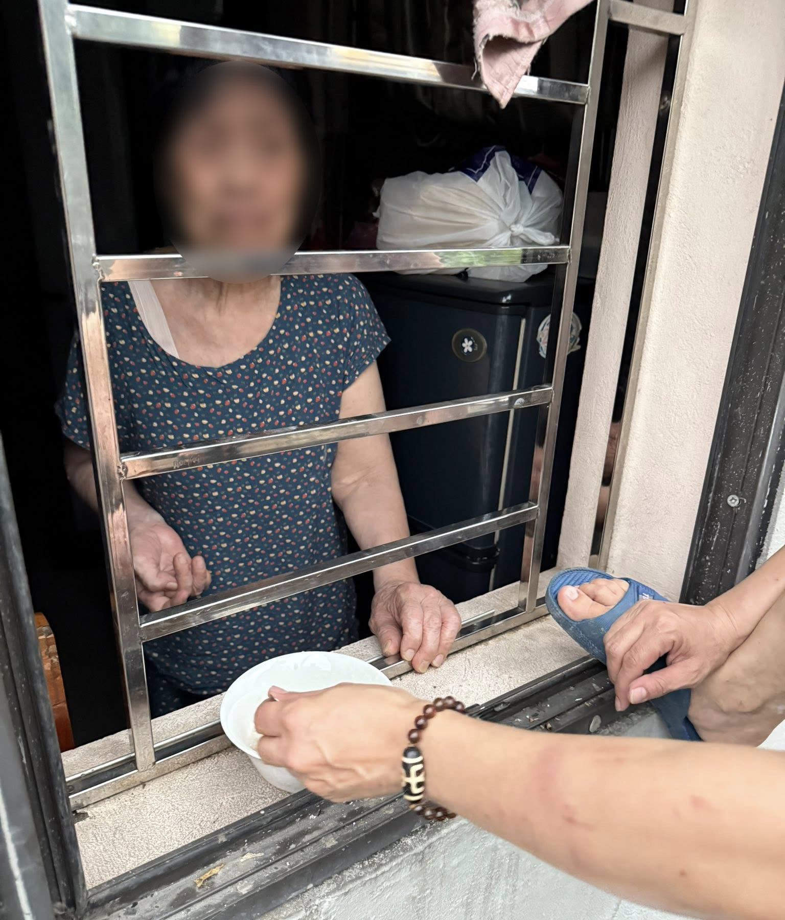 X&ocirc;n xao th&ocirc;ng tin cụ b&agrave; ở H&agrave; Nội "bị nhốt trong nh&agrave; của m&igrave;nh", con đưa cơm qua cửa sổ: Ch&iacute;nh quyền n&oacute;i g&igrave;?- Ảnh 1.