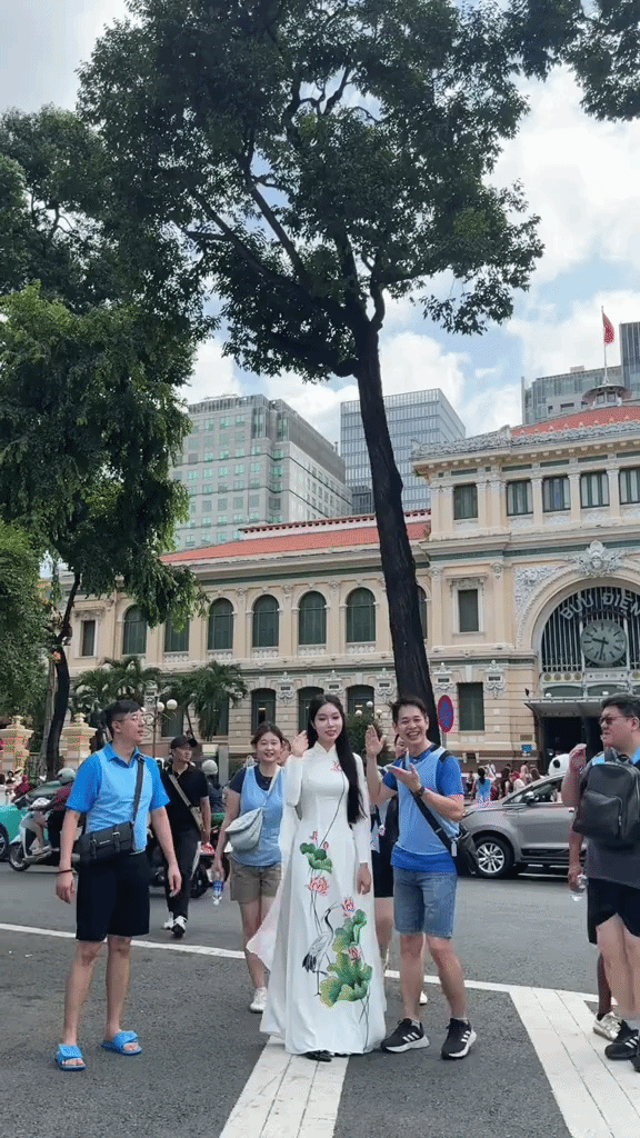Người nước ngo&agrave;i xếp h&agrave;ng chụp ảnh với c&ocirc; Việt SN 2002 cao 1m76 đứng trước Bưu điện TP.HCM - Ảnh 1.