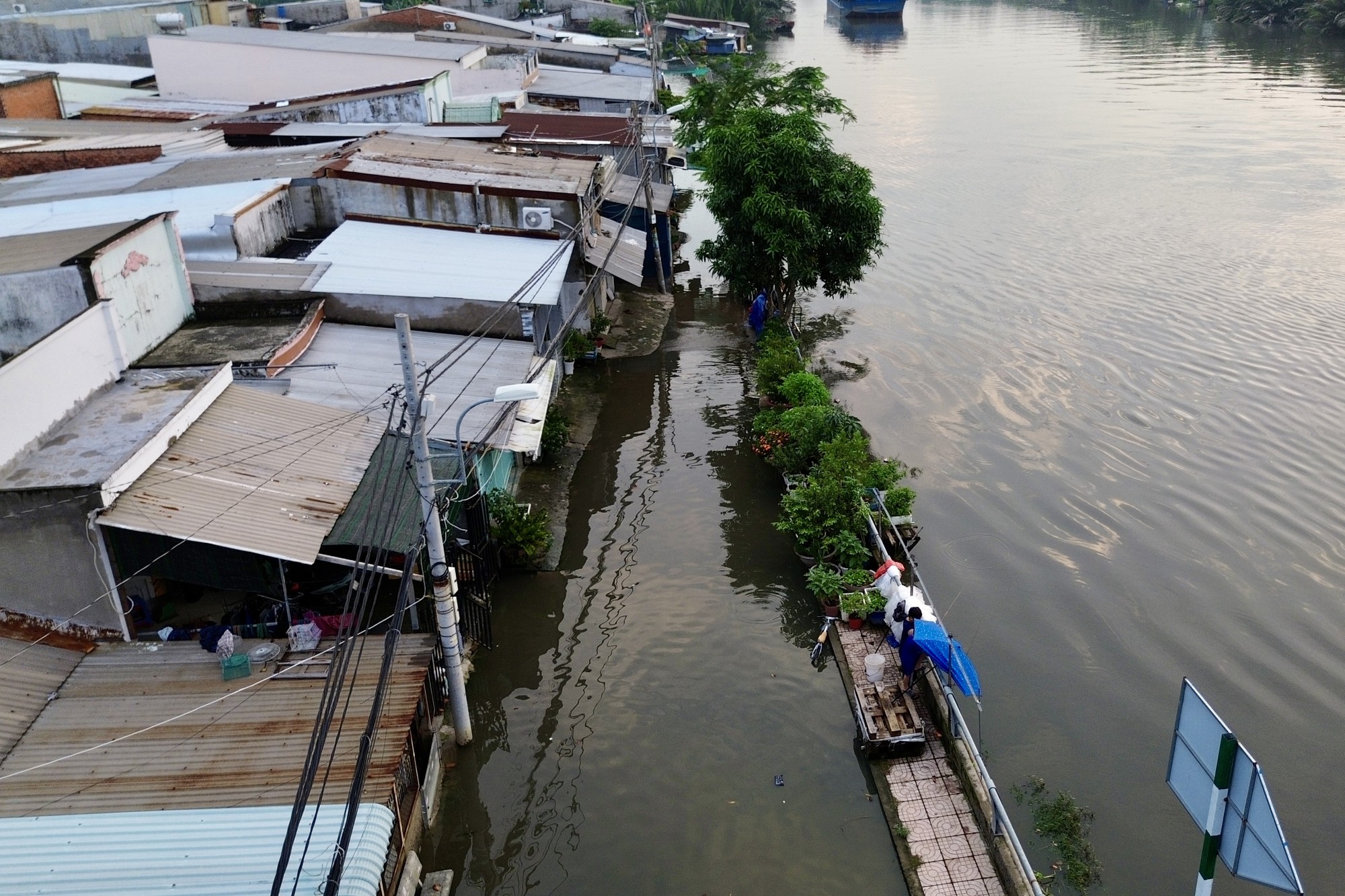 Cả ng&agrave;y nắng oi, tối một nơi ở TP.HCM lại ngập như s&ocirc;ng: Nước tr&agrave;n v&agrave;o nh&agrave;, người d&acirc;n lại k&ecirc; đồ "chạy triều"- Ảnh 1.