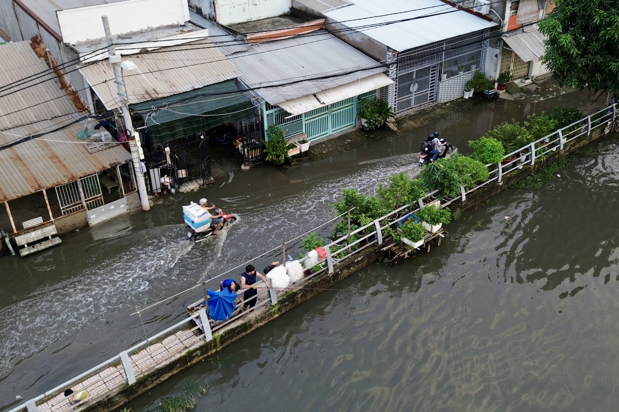 Cả ng&agrave;y nắng oi, tối một nơi ở TP.HCM lại ngập như s&ocirc;ng: Nước tr&agrave;n v&agrave;o nh&agrave;, người d&acirc;n lại k&ecirc; đồ "chạy triều"- Ảnh 2.