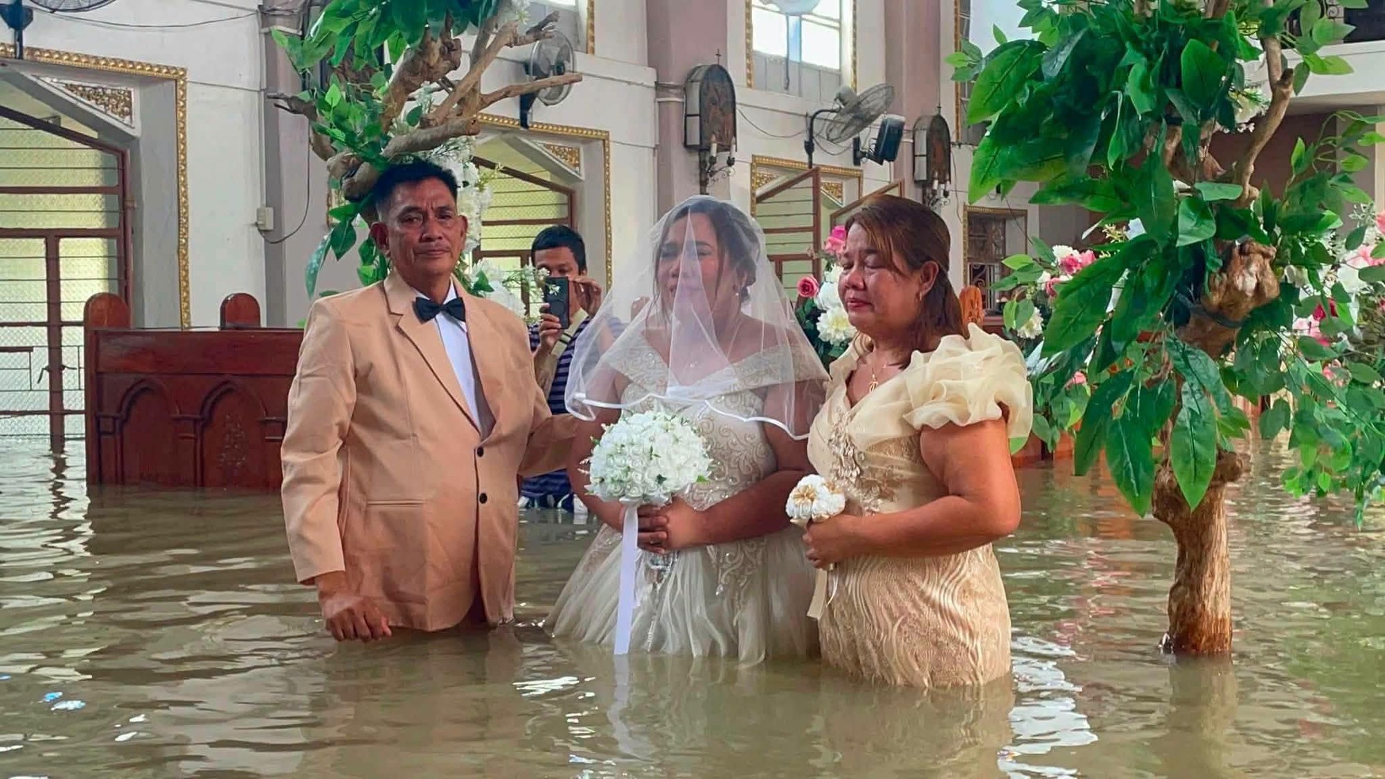 Nhà thờ ngập đến eo, cô dâu vẫn quyết mặc váy cưới lội nước bước vào lễ đường- Ảnh 3.