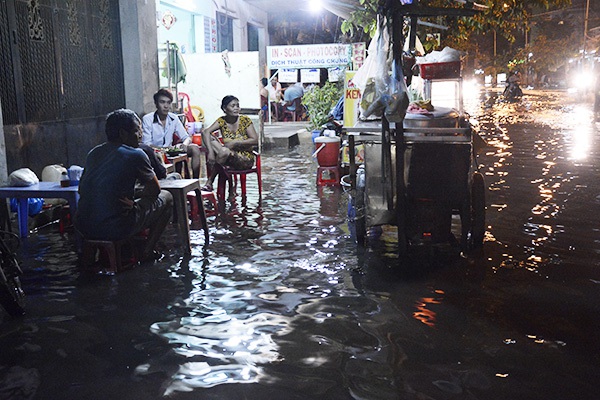 Người dân bì bõm ngồi ăn uống ngay trên đỉnh triều cường ngập ở Sài Gòn 13
