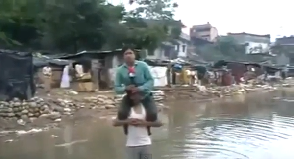 Phóng viên bị chỉ trích vì ngồi trên vai người dân vùng lụt để đưa tin 1