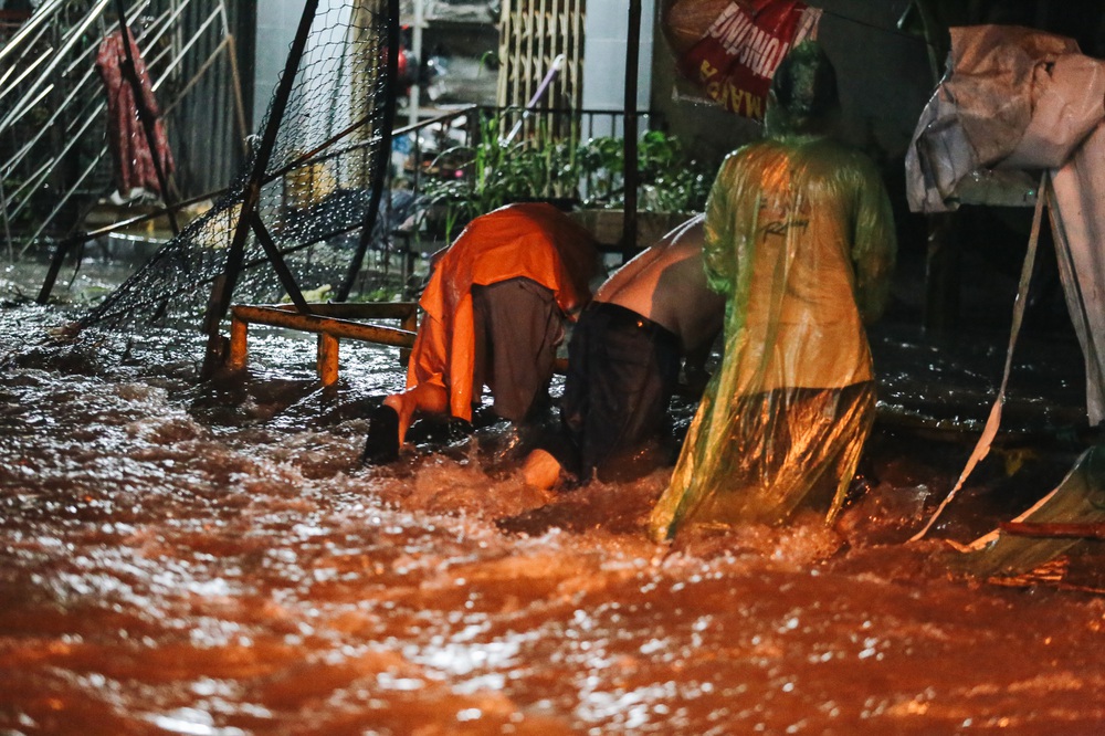 Người Sài Gòn vật lộn với đường ngập lút bánh xe, nước chảy cuồn cuộn như thác trong đêm mưa lớn - Ảnh 10.