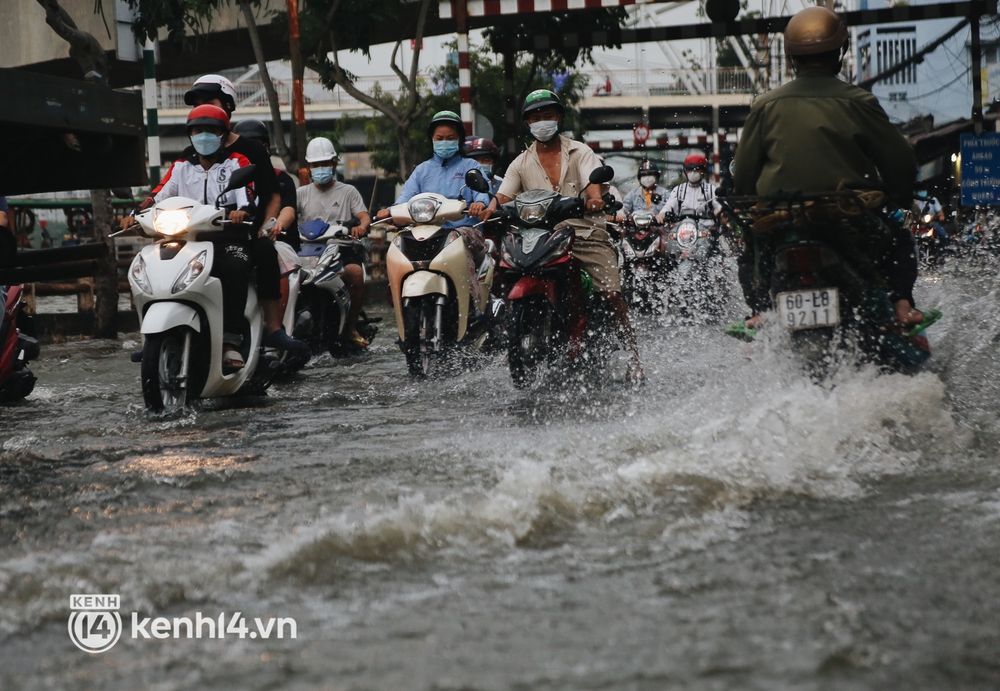 Người Sài Gòn vất vả lội nước, ngã sõng soài trên đường ngập sâu do triều cường dâng cao - Ảnh 4.