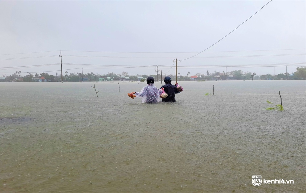 Ảnh: Đường quốc lộ ở Quảng Nam thành sông, dân lội nước ngập ngang bụng để về nhà - Ảnh 6.