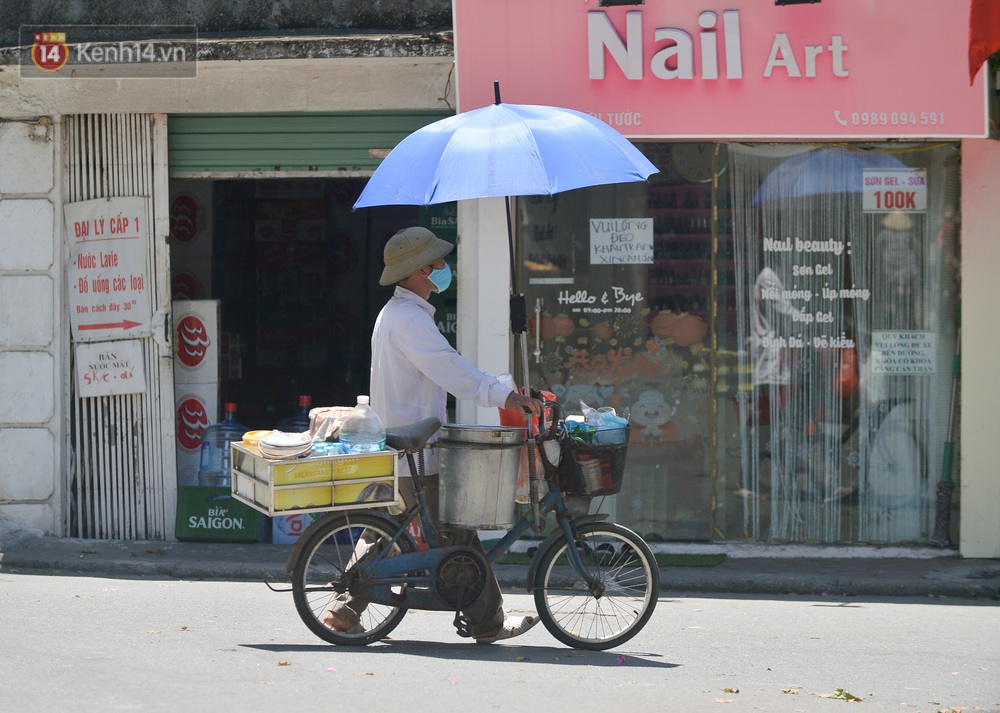Nắng nóng đỉnh điểm từ đầu hè lên đến 40 độ C tại Hà Nội: Nhựa đường tan chảy, người dân dùng nước tưới đường giữa trưa - Ảnh 7.