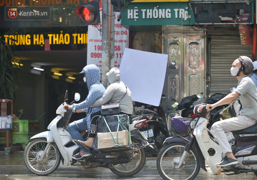 Nắng nóng đỉnh điểm từ đầu hè lên đến 40 độ C tại Hà Nội: Nhựa đường tan chảy, người dân dùng nước tưới đường giữa trưa - Ảnh 12.