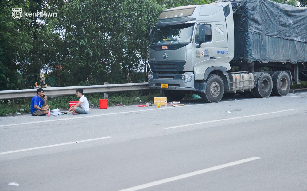 Tài xế container nấu ăn bên lề đường, chờ giấy thông hành để vào Hà Nội: Tôi bị kẹt ở đây 5 ngày rồi chưa chuyển hàng được - Ảnh 1. Tài xế container nấu ăn bên lề đường, chờ giấy thông hành để vào Hà Nội: Tôi bị kẹt ở đây 5 ngày rồi chưa chuyển hàng được - Ảnh 1.