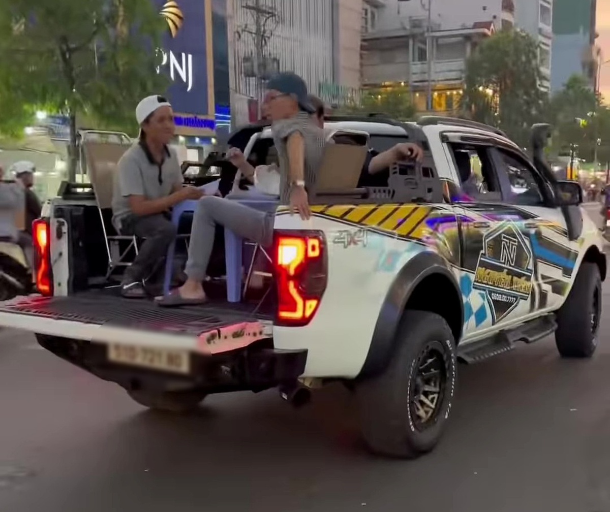 Nhóm thanh niên kê bàn ghế, ngồi ăn trên thùng xe bán tải đang chạy ở TP.HCM