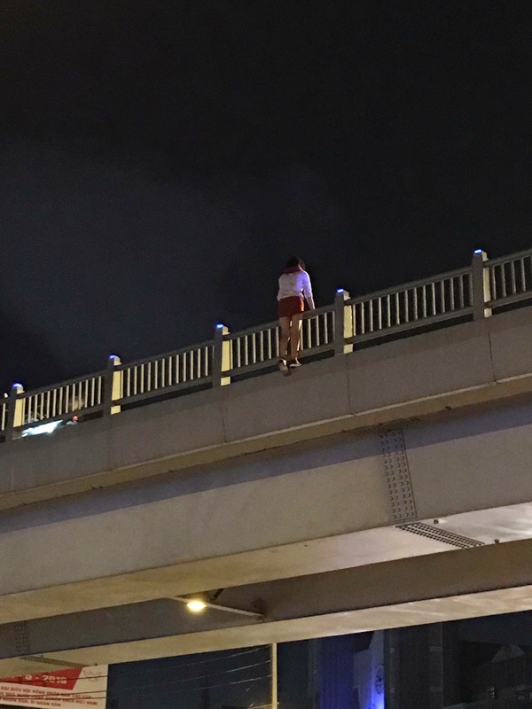 TP. HCM: Một c&ocirc; g&aacute;i trẻ leo ra lan can cầu vượt tự tử khiến nhiều người hốt hoảng - Ảnh 2.