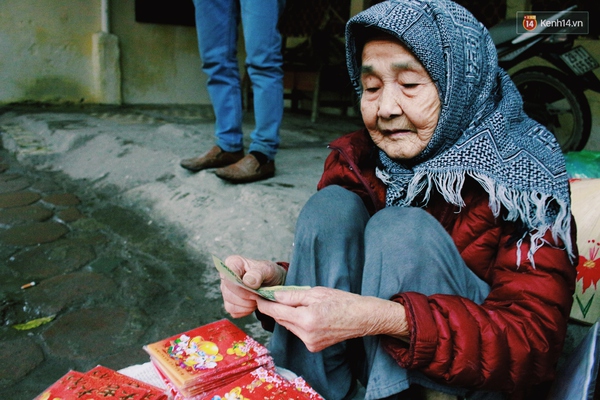 Hình ảnh cụ bà ngồi vỉa hè Hà Nội bán bao lì xì giữa trời giá rét khiến nhiều người cảm động - Ảnh 2.