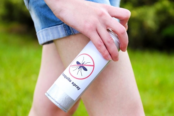 person-in-short-spraying-legs-with-insect-repellant-17854