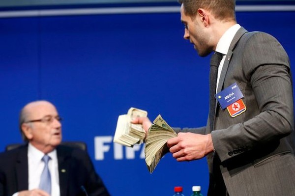 Lee-Nelson-throws-fake-money-at-Sepp-Blatter-during-FIFA-press-conference-4517b