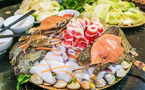 Mẹt lẩu hải sản thường được kèm theo những loại rau và gia vị nào?
